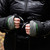 in use shot of fern green all weather performance, washable, packable, lightweight, mittens with a black liner being used