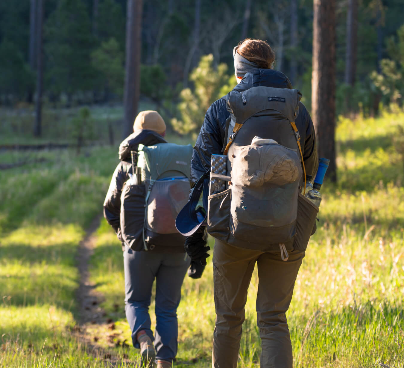 More Gear - two women with backpacks brimming with gear