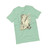 Laid out teal T-Shirt with design of a mountain and a person in a sleeping bag by the mountains.