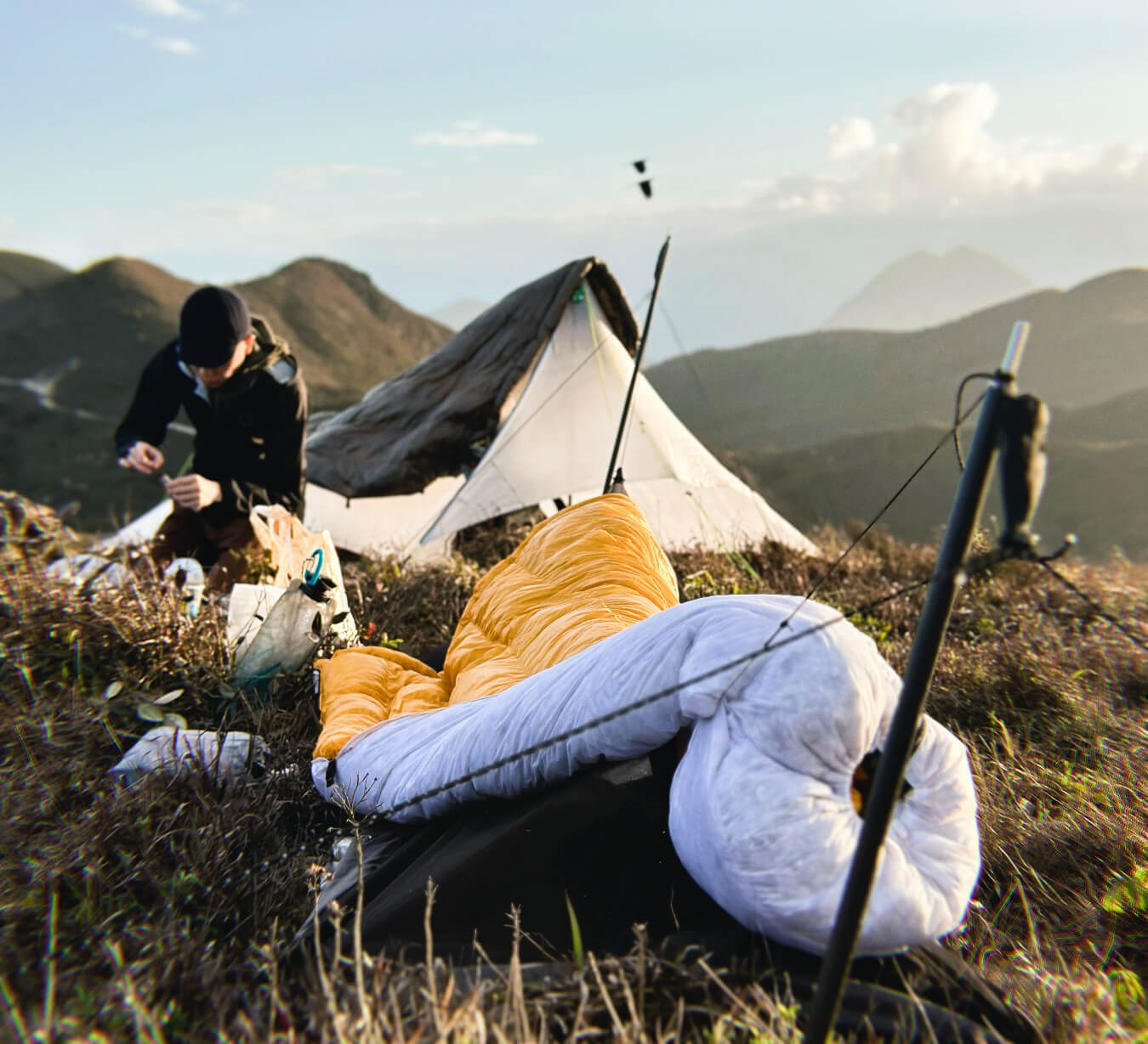 What is a Sleeping System - a backpacker setting up camp for the night with his quilt